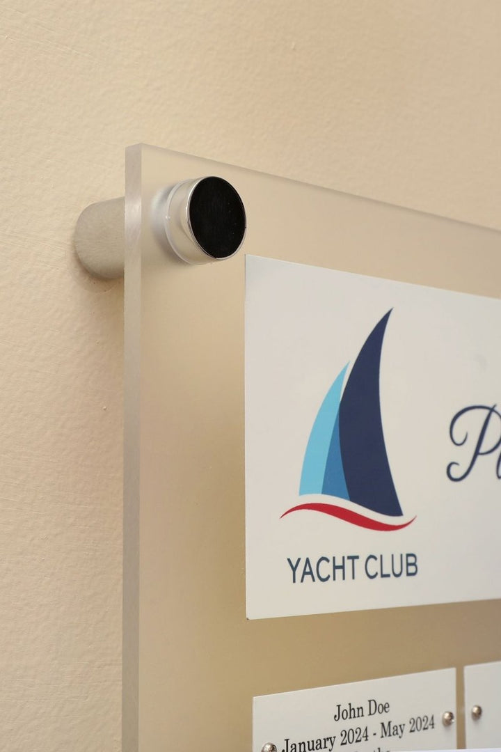 Close Up view of a 12 by 15 inch Frosted Acrylic plaque with Header Plate, Logo and 24 Individual white name plates for recognizing employees mounted on a wall.