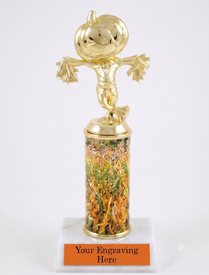 A golden scarecrow trophy figure standing on a custom rolled trophy column with printed corn field, mounted on a white marble base with an orange customizable engraving plate.