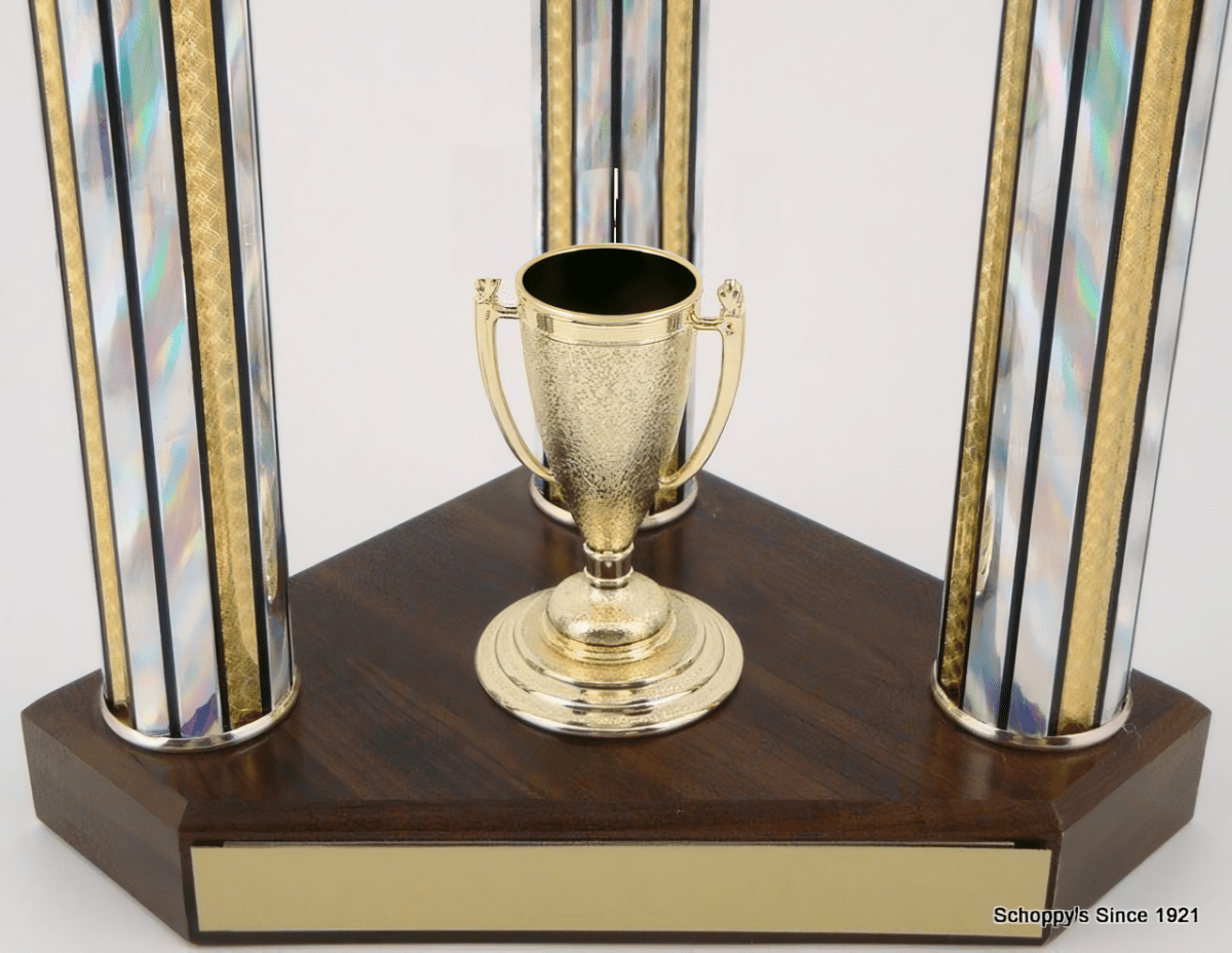 A trophy cup centerpiece on a dark wood base with two iridescent glass columns accented by gold trim, shown against a plain white background.