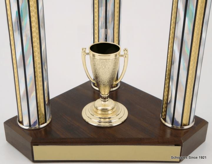 A trophy cup centerpiece on a dark wood base with two iridescent glass columns accented by gold trim, shown against a plain white background.