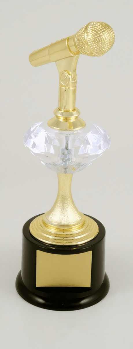 A microphone-shaped trophy with a gold-colored metallic top, a clear faceted crystal gem, a gold stem, and a round black base with a blank gold plaque.